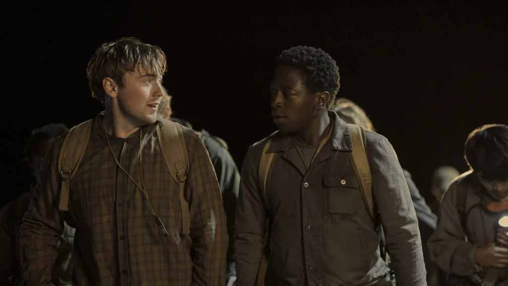 Cooper Hoffman e David Jonsson em cena de A Longa Marcha: Caminhe ou Morra, caminhando lado a lado durante a competição.