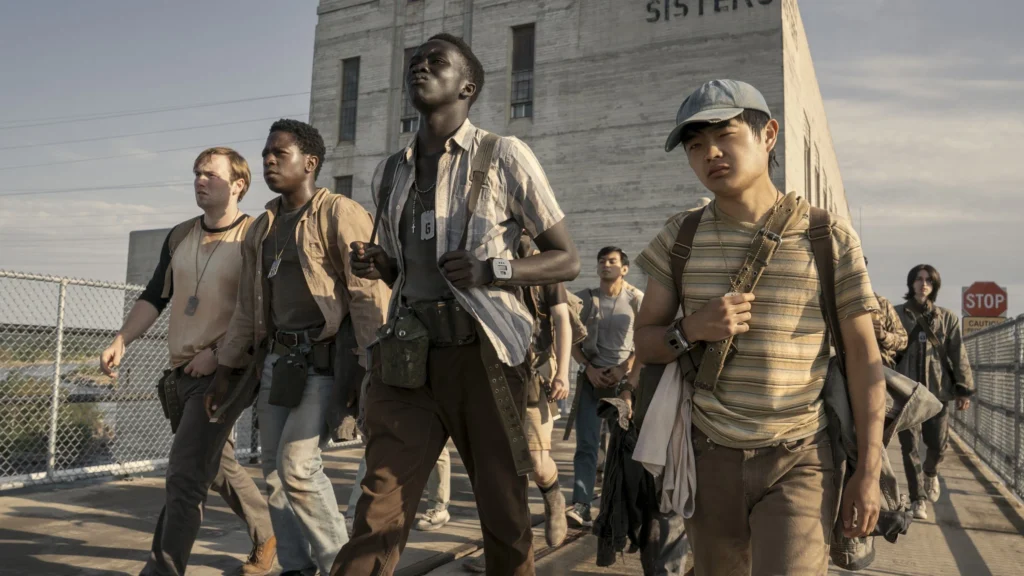 Cooper Hoffman, David Jonsson, Tut Nyuot e Ben Wang marcham juntos em cena do filme A Longa Marcha: Caminhe ou Morra.