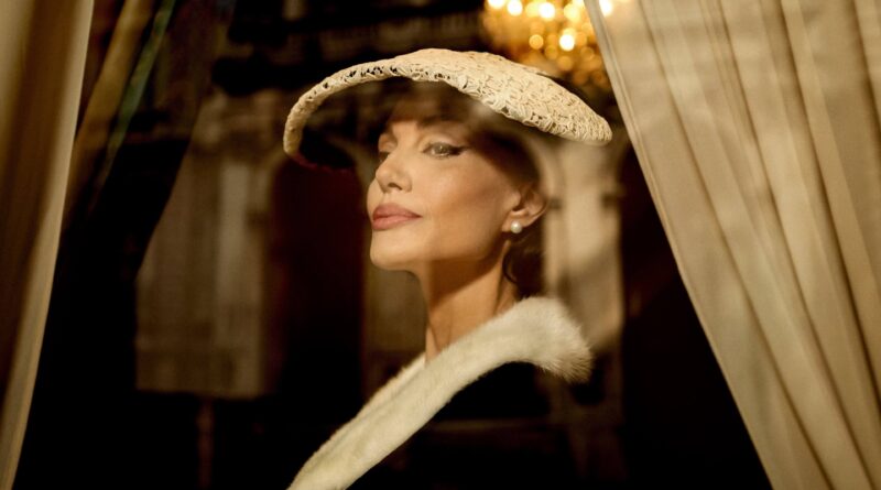Cena do filme Maria Callas mostrando a personagem principal com chapéu elegante e olhar marcante, transmitindo sofisticação – Multi Nerdz.