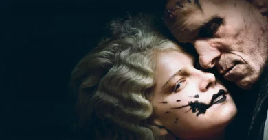 Fotografia em close-up com fundo escuro destacando os atores Jessie Buckley e Christian Bale caracterizados para o filme A Noiva. Jessie, em primeiro plano, possui cabelos loiros ondulados em estilo vintage e uma maquiagem preta borrada de forma expressiva ao redor dos lábios e da bochecha. Christian Bale está com o rosto colado ao dela, olhando para baixo, exibindo cicatrizes marcantes e pontos cirúrgicos na testa e no rosto, remetendo ao visual clássico do Monstro de Frankenstein. O clima da imagem é sombrio, gótico e intimista.