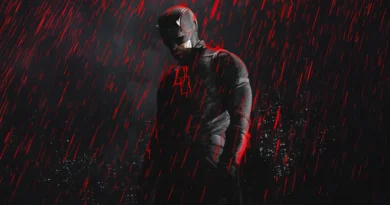 Pôster da segunda temporada da série Demolidor: Renascido, destacando o ator Charlie Cox como o herói Demolidor. Ele está no centro da imagem em uma pose sombria e imponente, com a cabeça levemente abaixada. O personagem veste um traje tático escuro e texturizado, incluindo o clássico capacete com pequenos chifres que cobre a parte superior do seu rosto, deixando apenas o queixo com barba por fazer à mostra. No peito do traje, brilha um emblema com as letras "DD" em neon vermelho. O cenário de fundo é escuro, revelando a silhueta de uma cidade à noite com algumas janelas de prédios acesas. Um efeito visual dramático mostra uma forte chuva caindo, mas as gotas de água são de um tom vermelho vivo e brilhante, criando reflexos avermelhados na silhueta do herói, como se fosse sangue. Capa da crítica da série no blog Multi Nerdz.