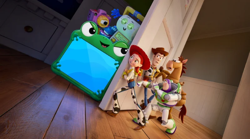 Cena da animação Toy Story 5 em um quarto com chão de madeira. À direita, os brinquedos clássicos Jessie, Buzz Lightyear, Woody e o cavalo Bala no Alvo estão encolhidos e escondidos atrás do batente de uma porta branca. Eles espiam o outro cômodo com expressões de medo, choque e apreensão. À esquerda, iluminados pelo forte brilho azul de uma tela, estão um grupo de brinquedos eletrônicos modernos, com grande destaque para um tablet envolto em uma capa protetora verde em formato de sapo com olhos grandes. Atrás do tablet, empilham-se outros gadgets tecnológicos, incluindo uma câmera digital roxa e um dispositivo inteligente com tela sorridente. Capa da crítica do filme Toy Story 5 no blog Multi Nerdz.