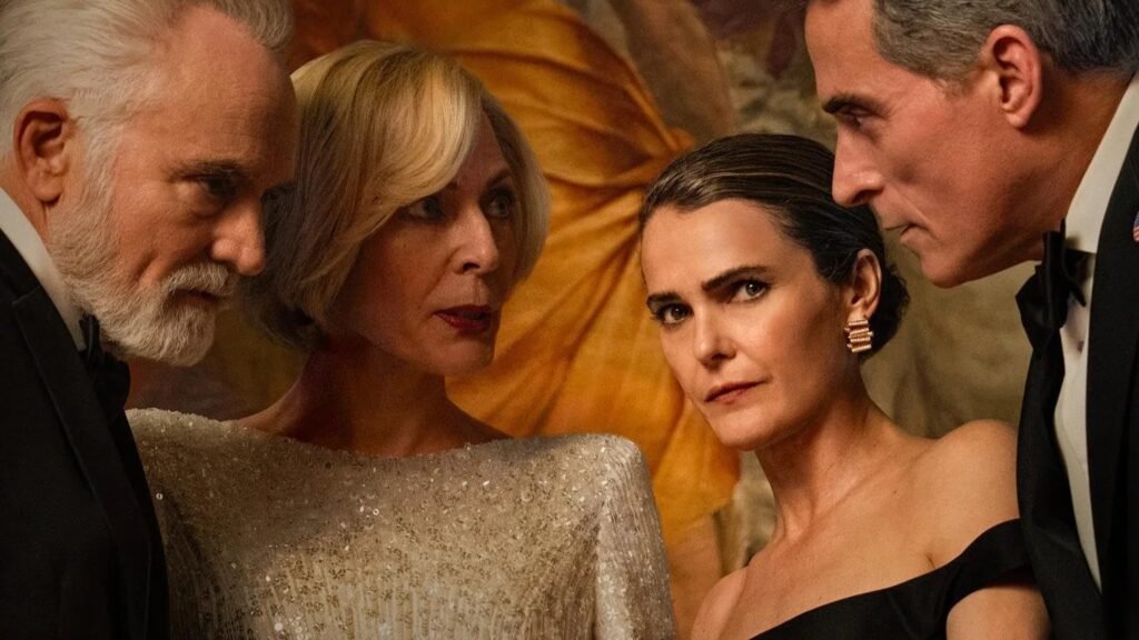 Imagem promocional da 4ª temporada de ‘A Diplomata’, da Netflix, usada no blog Multi Nerdz. Da esquerda para a direita, Bradley Whitford como Todd Penn, Allison Janney como a presidente Grace Penn, Keri Russell como a embaixadora Kate Wyler e Rufus Sewell como o vice-presidente Hal Wyler aparecem reunidos em trajes formais, com expressões sérias, diante de um cenário elegante em tons dourados.
